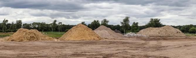 Blick in eine Kiesgrube mit Sandhaufen und einigen Reifenspuren foto