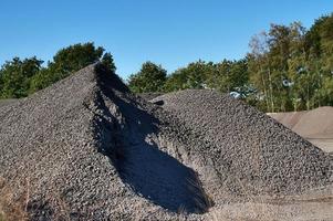 Blick in eine Kiesgrube mit Sandhaufen und einigen Reifenspuren foto