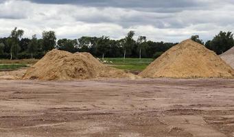 Blick in eine Kiesgrube mit Sandhaufen und einigen Reifenspuren foto