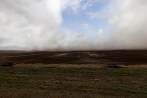 Staub von Torfgruben, der gegen den Himmel fliegt foto