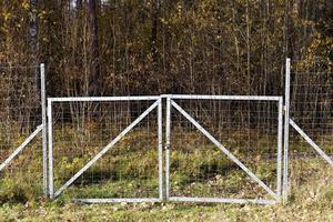 Metallzäune in der Nähe des Waldes, die Tiere vor der Fahrbahn schützen foto