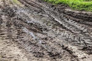 Autoreifenspuren auf einer sandigen Straße foto