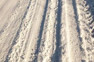 Spuren des Autos auf Schnee foto