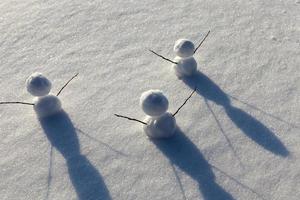 Spiele im Schnee mit dem Erstellen mehrerer Schneemannfiguren foto