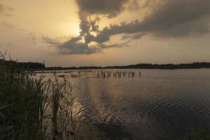 See während des Sonnenuntergangs mit gelb-orangeem Himmel foto