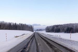 asphaltierte Straße im Winter mit Schnee bedeckt foto