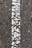 asphaltierte Straße mit weißen Fahrbahnmarkierungen foto