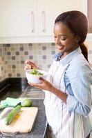 afrikanische Hausfrau, die grünen Salat isst foto