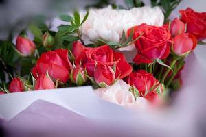 Geschenkstrauß mit roten Rosen und rosa Nelken foto