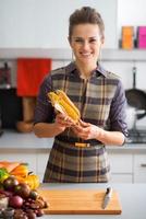 Porträt der glücklichen jungen Hausfrau mit Mais