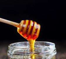 ein Löffel für Honig zusammen mit hochwertigem Bienenhonig foto