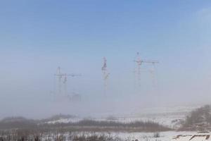 Baukräne auf einer Baustelle im Winter foto