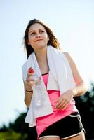 gesunde fröhliche junge Frau des Fitnesssports, die Landschaft im Freien läuft foto