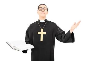 junger fröhlicher Priester, der zu Gott betet foto