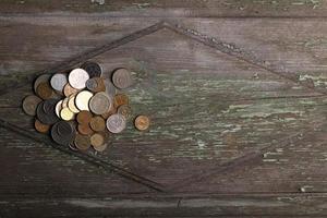 Draufsichtmünzen auf altem hölzernem Schreibtisch mit Kopienraum