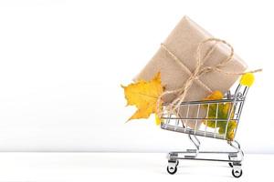 Herbstverkauf. rabattbanner für werbung. Einkaufswagen und gefallene gelbe Blätter auf weißem Hintergrund.