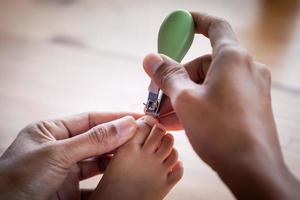 Vater schneidet Zehennägel für sein Baby
