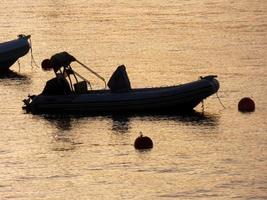 Hintergrundbeleuchtung von Sportbooten, die in einer Bucht vor Anker liegen foto