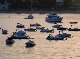 Hintergrundbeleuchtung von Sportbooten, die in einer Bucht vor Anker liegen foto