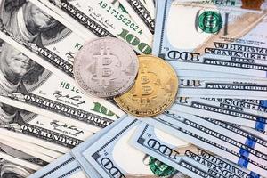 Platin- und Gold-Bitcoin auf dem Hintergrund von Hundert-Dollar-Scheinen foto