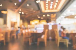 restaurantinnenraum mit kunden- und holztisch verwischen abstrakten hintergrund mit bokeh-licht foto