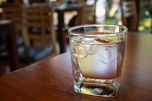 Glas Wasser auf Holztisch im Restaurant foto