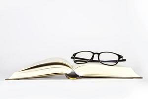 schwarze Brille auf geöffnetem Buch foto