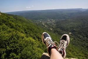 Wanderschuhe, die Spaß haben und einen wunderbaren atemberaubenden Bergblick genießen. Lifestyle- und Reisekonzept. foto