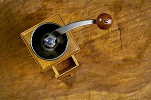 vintage kaffeemühle. alte retro handbetriebene kaffeemühle aus holz und metall. manuelle kaffeemühle zum mahlen von kaffeebohnen. auf dem alten hölzernen background.soft-Fokus. foto