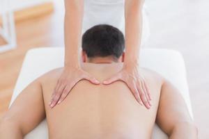 Physiotherapeutin, die ihrer Patientin eine Rückenmassage macht foto