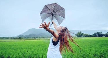 asiatische frauen reisen im urlaub entspannen. Frauen stehen in Regenschirmen. auf der wiese während der regenzeit.thailand foto