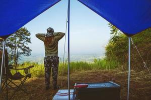 Reisen Entspannen im Feriencamping am Berg. Junge Touristen, die auf dem Berg im Dschungel campen, entspannen sich. Natur grüne Berge reichen Campingzelt. foto