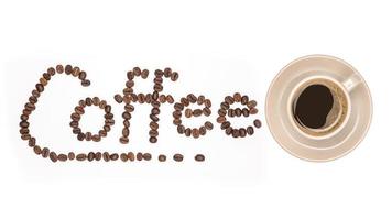 Kaffeetasse und Kaffeebohnen verbreiten mit Schrift das Wort aus Kaffeebohnen isoliert auf weißem Hintergrund foto