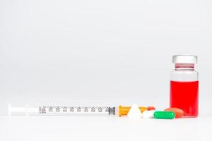 Injektionsfläschchen und Medizin Tablette auf weiß