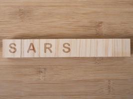 Sars-Wort auf Holzblock geschrieben foto