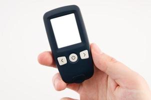 Hand hält Glukometer mit leerem Display isoliert auf weißem bac foto