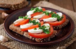 nützliche Diät-Sandwiches mit Mozzarella, Tomaten und Roggenbrot foto