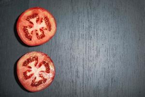 Gesundes Essen Tomatenscheibe auf schwarzem Holztisch kopieren. foto