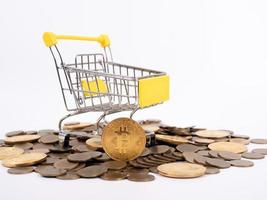 Kryptowährung bezahlen Der Einkaufswagen im Supermarkt ist mit Goldmünzen von Bitcoin auf weißem Hintergrund gefüllt. Platz kopieren foto