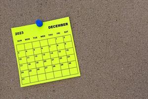 dezember 2023 gelber haftnotizkalender mit pin auf kork-bulletin-plakatwand foto