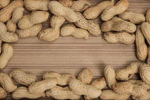 Erdnüsse in Schalen über Holz Hintergrund foto