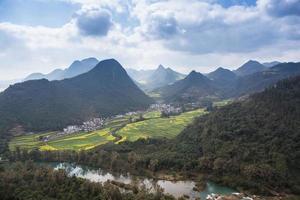 frühlingsfrische landschaft mit bunten feldern, sonnenaufgangshimmel und wunderschönem hügeltal foto