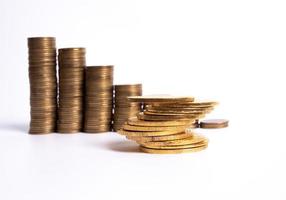 Einsparungen, zunehmende Spalten von Goldmünzen isoliert auf weißem Hintergrund foto
