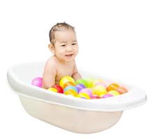 glücklicher kleiner Junge ist im weißen Bad gebadet