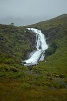 Atemberaubender Wasserfall in Skye mit üppiger grüner Vegetation foto