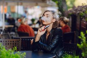schöne glamouröse brünette rauch elektronische zigarette foto