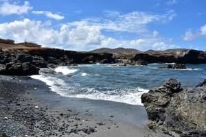 Schwarzer Sandstrand an der Küste von Aruba foto