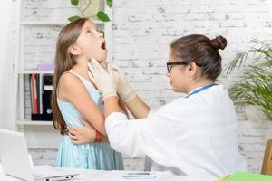 junger Arzt untersucht ein kleines Mädchen foto