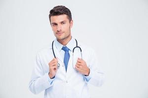 Porträt eines männlichen Arztes, der mit Stethoskop steht foto