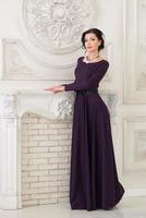 Frau im eleganten violetten langen Kleid im Studio foto